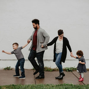 A family, including two children, walks hand-in-hand, symbolizing their arrival. 