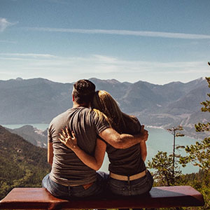  A couple embraces while looking at a scenic landscape.